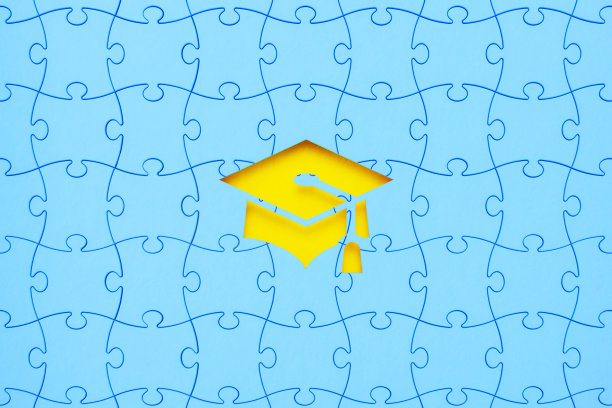 教育概念-蓝色拼图块形成一个剪纸毕业帽在黄色的背景图片下载