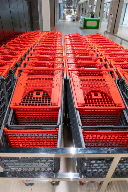 塑料购物车排在购物超市的商店。购物中心里的红色购物车图片下载