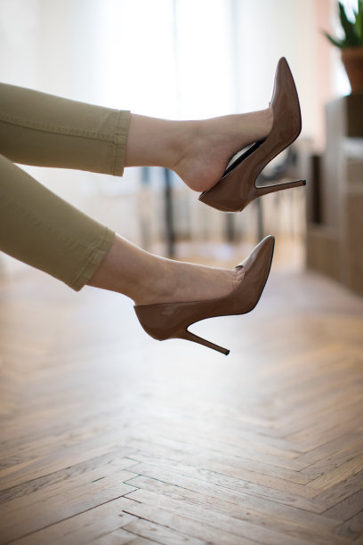 疲惫的女商人脱下高跟鞋，躺在家里的沙发上休息图片下载