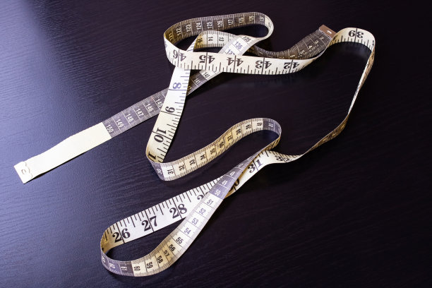 木制桌子上的黄色裁缝卷尺图片下载