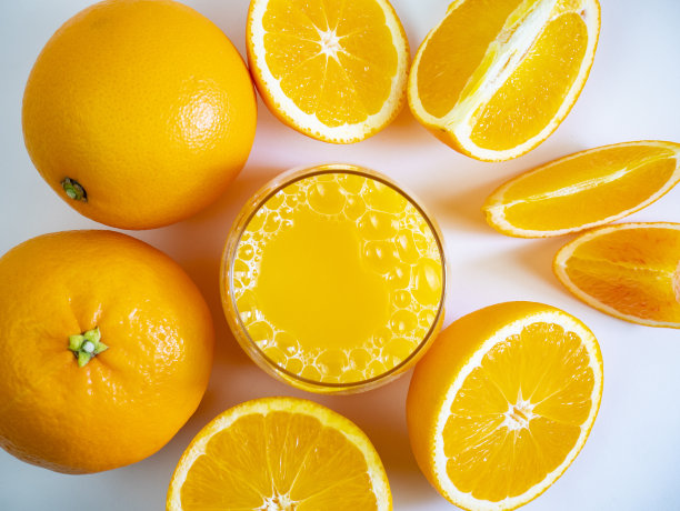 橙汁和橙果的成分，整块和切片。平的。完整的框架。从上面看是一杯橙色的。健康的饮料。图片下载