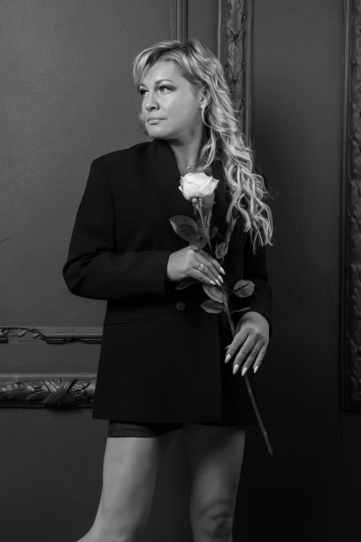 肖像照片可爱的中年45岁的金发女人在家庭房间与玫瑰图片下载