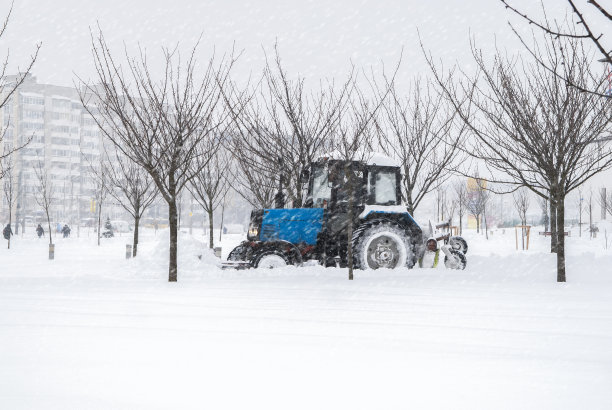 白雪覆盖的街道。扫雪机清除城市道路积雪。暴风雪，暴风雪交通。天气气候灾难。冬天的城市风光。雪后的雪堆图片下载