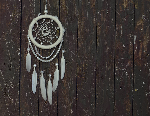 漂亮的手工波西米亚捕梦网白色羽毛和珠子，与复制空间。图片下载