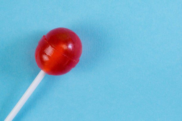 一根红色的棒棒糖，蓝色的背景是领空，从上面看。图片下载