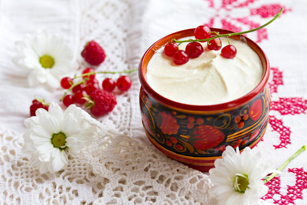 酸奶油和醋栗浆果放在一个漂亮的杯子里。图片下载