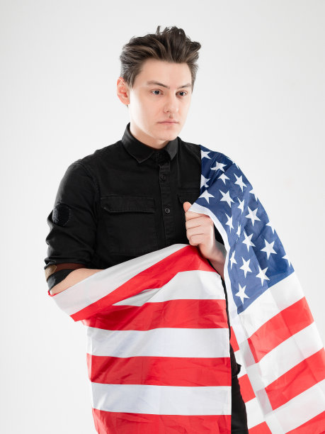 画室里一个白人男子的肖像，背景是灰色。概念与复制空间。他穿着黑衬衫，在镜头前摆姿势。美国国旗图片图片下载