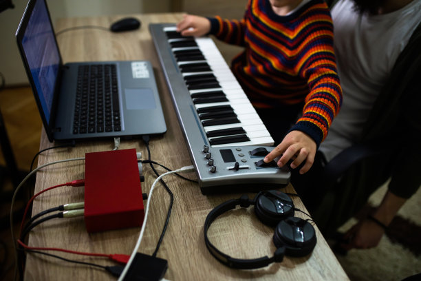 一个小男孩正在学习如何制作电子音乐图片下载