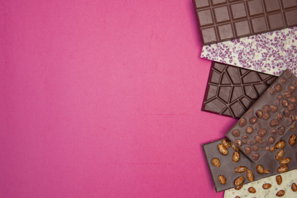 许多，不同的，甜的，精致的巧克力棒在粉红色的背景图片下载