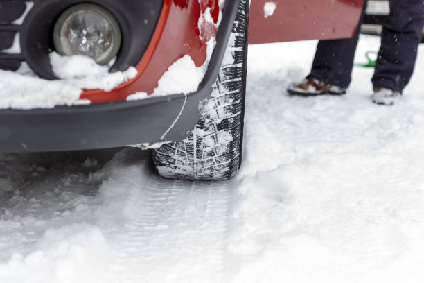 汽车轮胎在被雪覆盖的冬季道路上的照片。图片下载