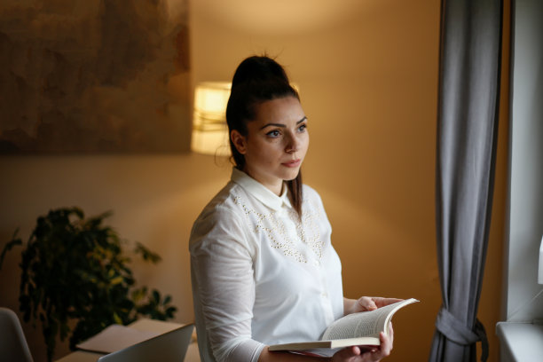 年轻的白人女性在繁忙的现代工作场所的肖像。库存图片图片下载