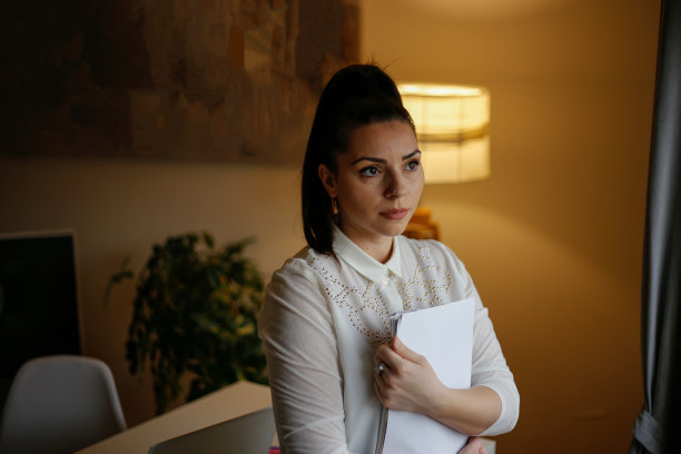 年轻的白人女性在繁忙的现代工作场所的肖像。库存图片图片下载