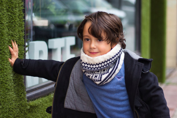 拿着围巾靠在橱窗上的男孩图片下载