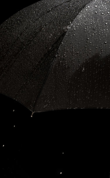 一个打开的黑色雨伞与雨湿的特写镜头图片下载