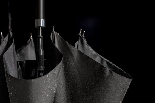 特写工作室拍摄的一个折叠的黑色伞与黑色背景图片下载