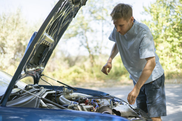 年轻男子站在汽车附近，打开引擎盖，修理发动机的一些问题图片下载