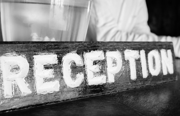 大堂木质接待标志，单色。酒店的信息板，黑白相间。入住酒店。旧木板上的字接收。汽车旅馆的服务理念。的接待。旅游和度假的概念。图片下载
