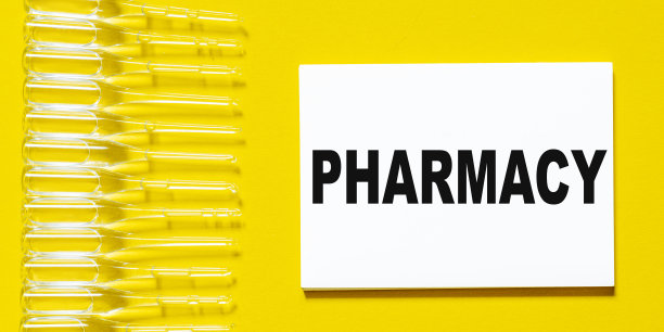 “药房”这个词写在一张黄色背景的纸上，俯视图。医疗保健理念。图片下载