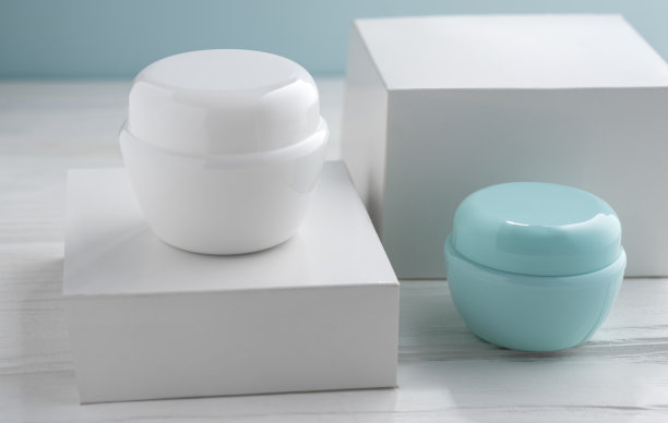 两个白色和蓝色的奶油容器和空白的白色盒子图片下载