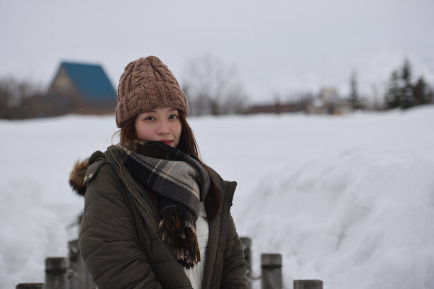 美丽的年轻女子在白雪覆盖的公园放松图片下载