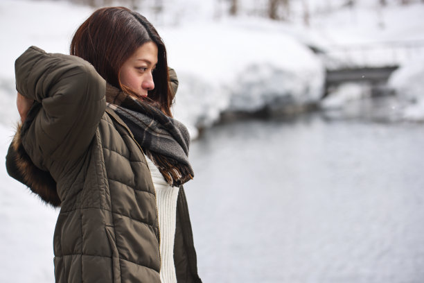 美丽的年轻女子放松在公园与大雪图片下载