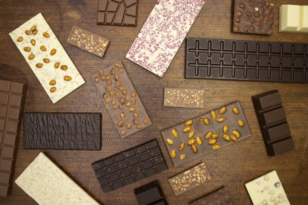 许多不同种类的巧克力躺在棕色的背景上图片下载