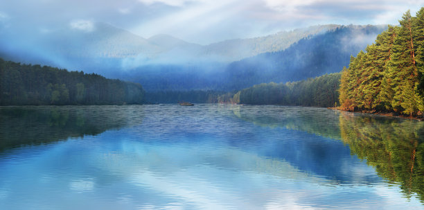 倒影在湖中的山峰在雾中，全景景观图片下载
