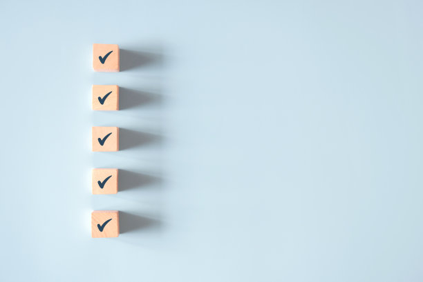 木质立方体，蓝色背景上有检查标记，检查表概念。图片下载