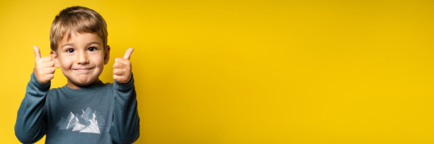 快乐的白人小男孩肖像前黄色背景大拇指向上-童年成长和成就概念-正面视图腰部向上复制空间图片下载
