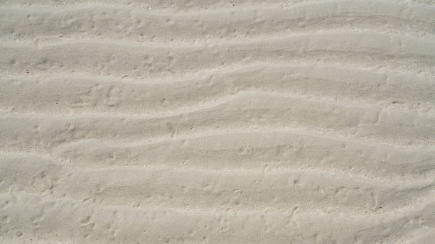 退潮时平坦沙滩上的天然沙纹图案图片下载