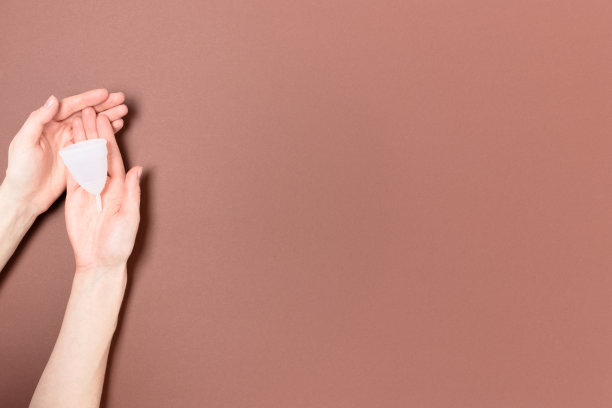 手握月经杯。极简的零浪费概念与地方的文本。图片下载