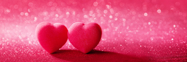 两颗心在闪亮的散景背景粉闪光顶部-情人节的概念图片下载