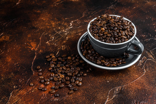 在杯子里深烤的咖啡豆。黑暗的背景。前视图。本空间图片下载