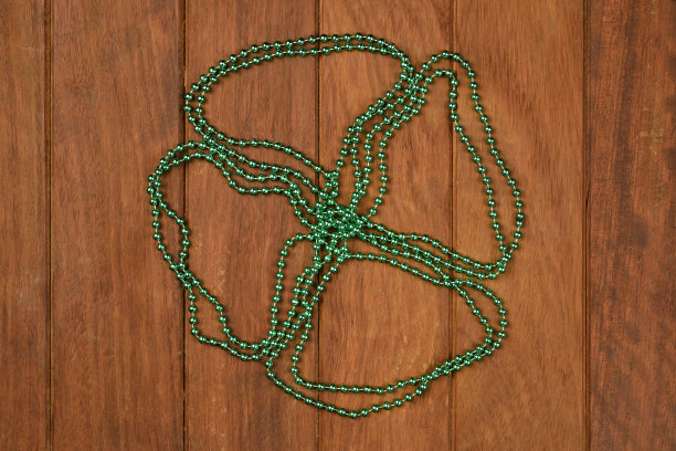 绿色三叶草项链上的木制背景图片下载