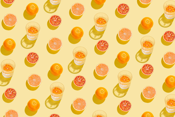 用切好的葡萄柚、血橙和柠檬水或水在黄色背景上做成的创意图案。夏季水果和点心概念。最小的风格。阳光公寓。俯视图图片下载
