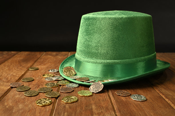绿色的帽子和幸运的硬币在木材背景图片下载