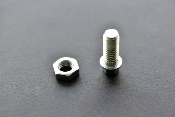 黑色背景上的银色螺栓和螺母图片下载