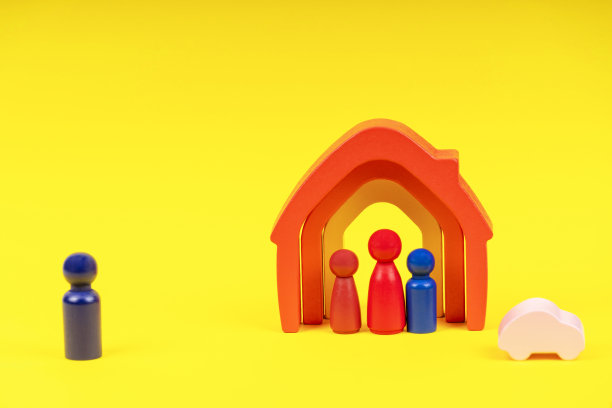 黄色背景的木制小人站在房子里。离婚，父母之间的冲突图片下载