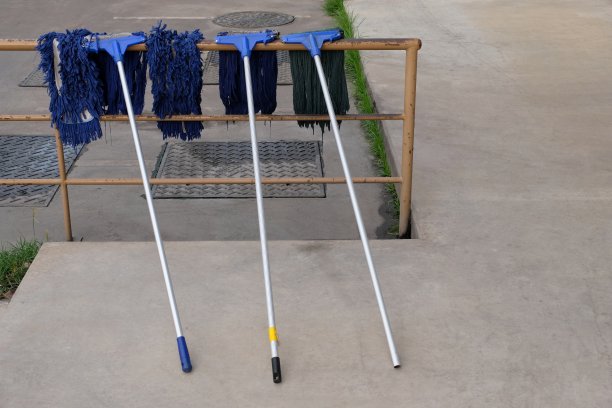 旧拖把挂在金属栏杆上晾干图片下载