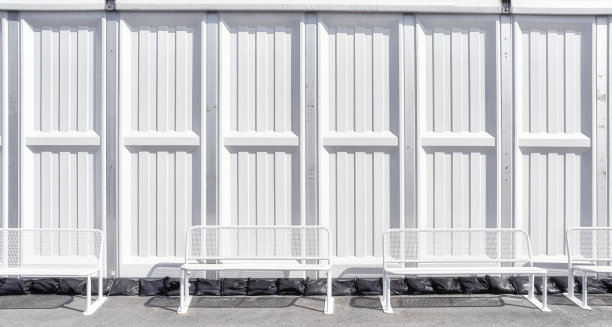 长长的白色金属条墙和公园长椅。图片下载