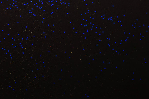 金色的闪光和蓝色的星星在黑色的背景。假日抽象结构图片下载