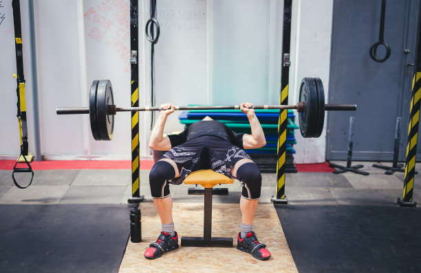 在健身房做卧推的男人图片下载