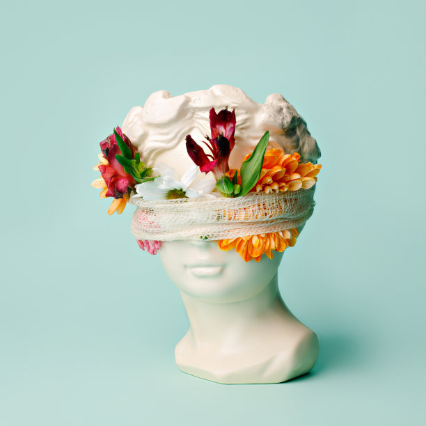 古董头雕像包裹着绷带和充满活力的鲜花在明亮的薄荷背景图片下载