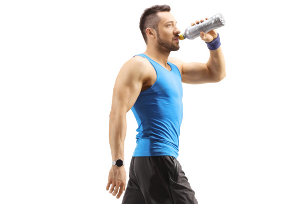肌肉发达的年轻人在运动服装行走和喝运动能量饮料图片下载