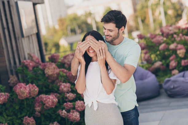 有趣的情侣在散步的家伙手掌盖女士的眼睛穿休闲衣服花园公园户外的照片图片下载