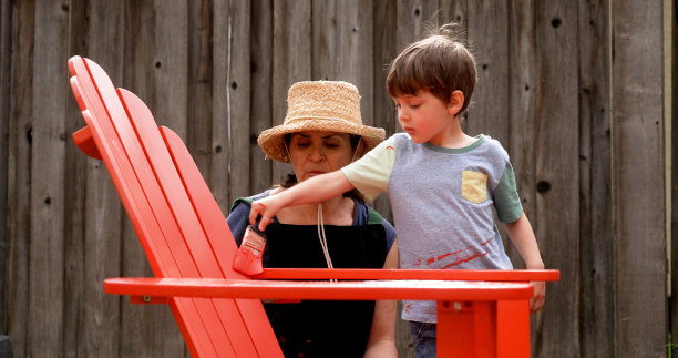 一个成熟的女人和她的儿子在自家后院画沙滩椅图片下载