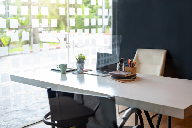 办公场所，桌上有笔记本电脑、咖啡、书籍和其他设备。图片下载