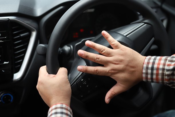 驾驶时按喇叭的人坐在方向盘压车，按喇叭的声音警告其他人在交通概念。图片下载