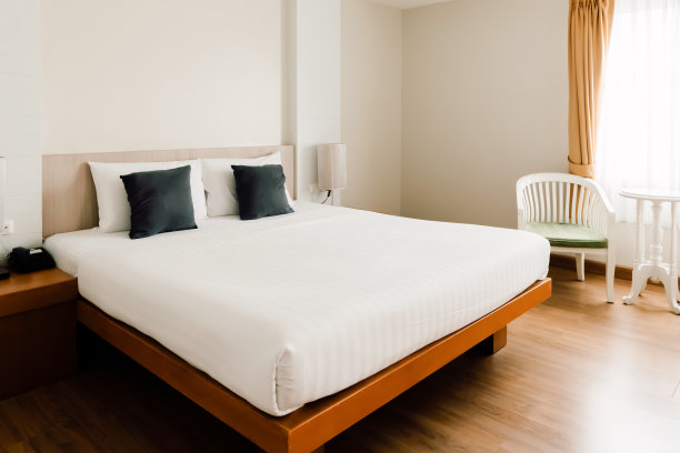 干净的白色卧室，室内，现代风格与枕头和吹，木材床单，椅子家具装饰家居室内室内极简主义12月18日上午社论图片下载