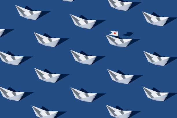 爱的船。用蓝色背景的纸船制作的创意图案。图片下载